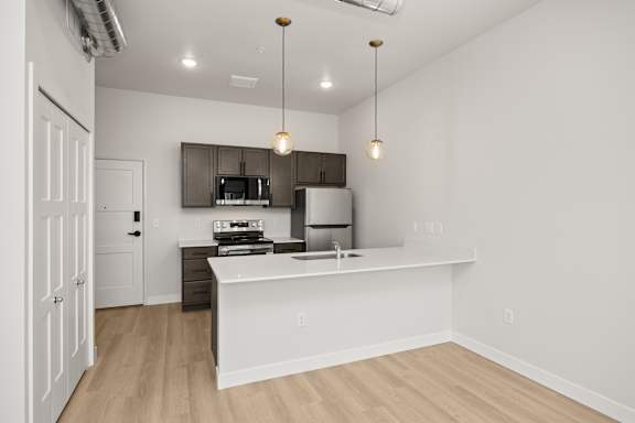 A kitchen with a white counter and a microwave above it.