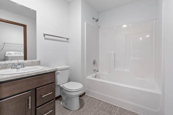 A white bathroom with a toilet, sink, and bathtub.