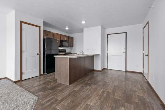 A kitchen with a refrigerator, microwave, and oven.