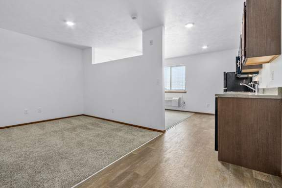 A room with a carpeted floor and a wooden cabinet.