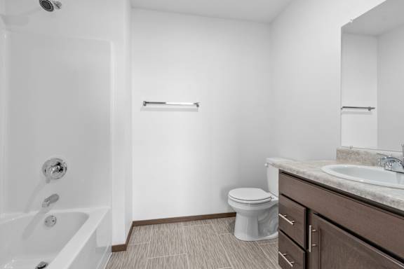 A white bathroom with a toilet, sink, and bathtub.