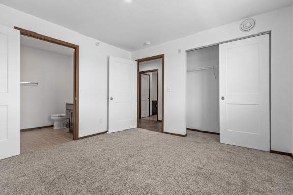 A spacious room with carpeted floor and white walls.