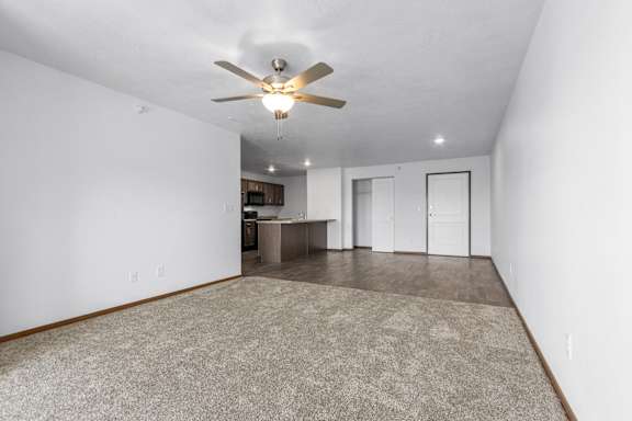 A room with a ceiling fan and a carpeted floor.