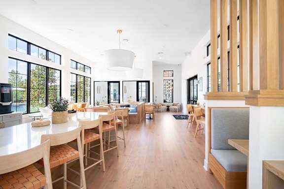 A modern dining room with wooden chairs and a white table.