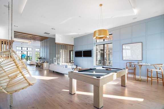 A room with a pool table and a chair swing.