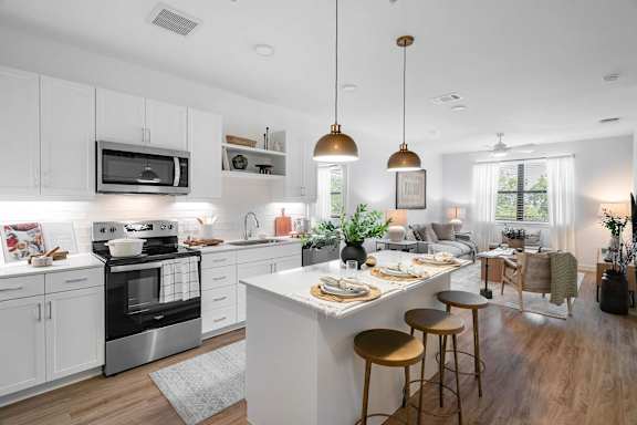 A modern kitchen with a large island and stools.