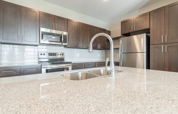 a kitchen with stainless steel appliances and marble counter tops at The Fitzroy San Marcos, Texas