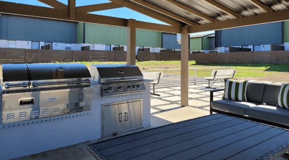a grill and a table with chairs at Ivy Plains at Brooks Apartments, Texas, 78223