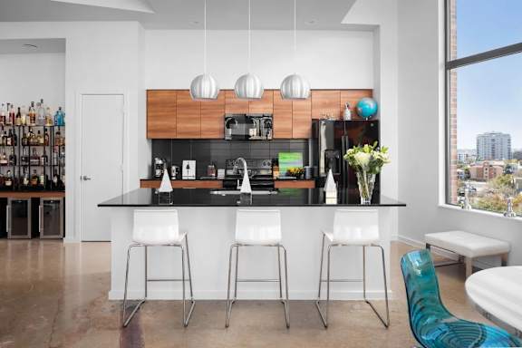 Kitchen island with bar seating and pendant lighting at THE'68 Apartments, San Antonio, TX