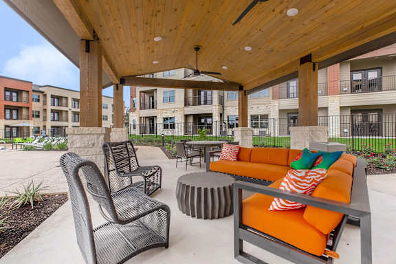 A patio with a table and chairs is surrounded by buildings.