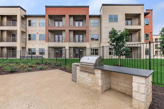 Apartment complex with a stone bench in front.