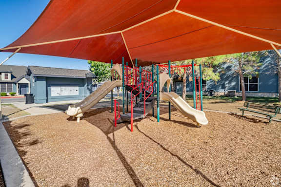 Playground with shade structure and climbing equipment at Houston Street Townhomes Apartments, Texas