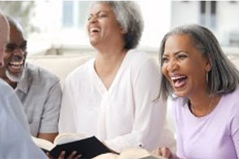 A group of people are gathered around, laughing and enjoying each other's company.