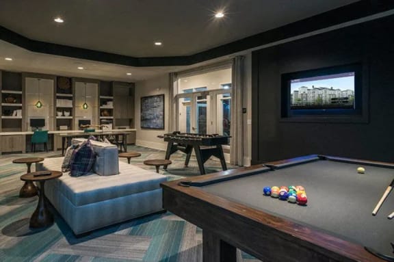 a large living room with a pool table and a flat screen tv
