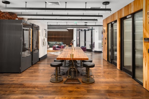 a large conference room with a long wooden table and stools at Abberly Foundry Apartment Homes, Nashville