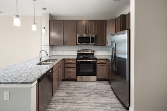an empty kitchen with granite countertops and stainless steel appliances at Abberly Liberty Crossing Apartment Homes, North Carolina, 28269