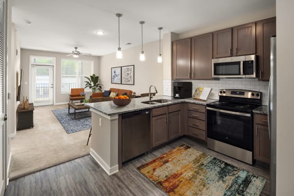 an open kitchen and living room with a dining area and a couch