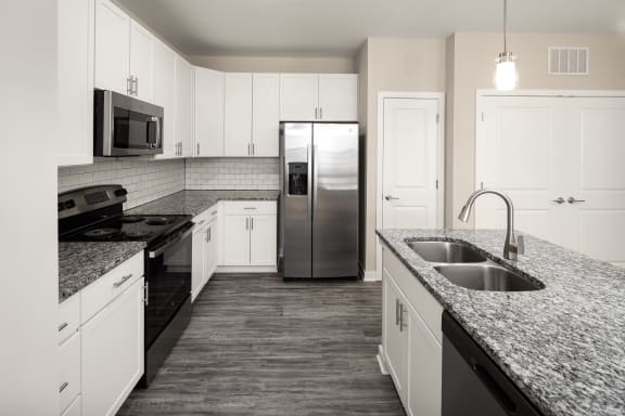 a kitchen with granite counter tops and a stainless steel refrigerator at Abberly Liberty Crossing Apartment Homes, Charlotte, 28269