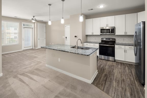 a kitchen with white cabinets and a granite counter topat Abberly Liberty Crossing Apartment Homes, North Carolina