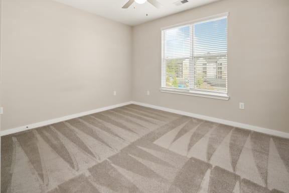 an empty living room with carpet and a windowat Abberly Liberty Crossing Apartment Homes, North Carolina, 28269