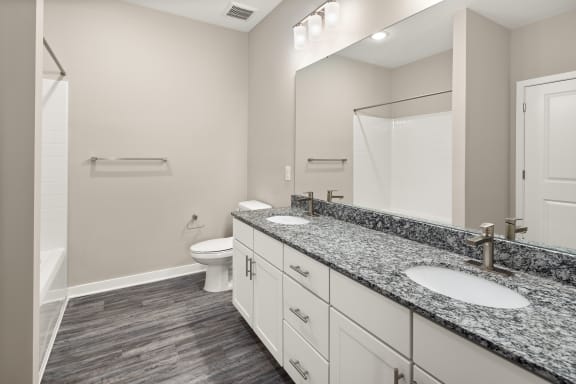 a bathroom with granite counter tops and a toilet and a shower at Abberly Liberty Crossing Apartment Homes, Charlotte, 28269