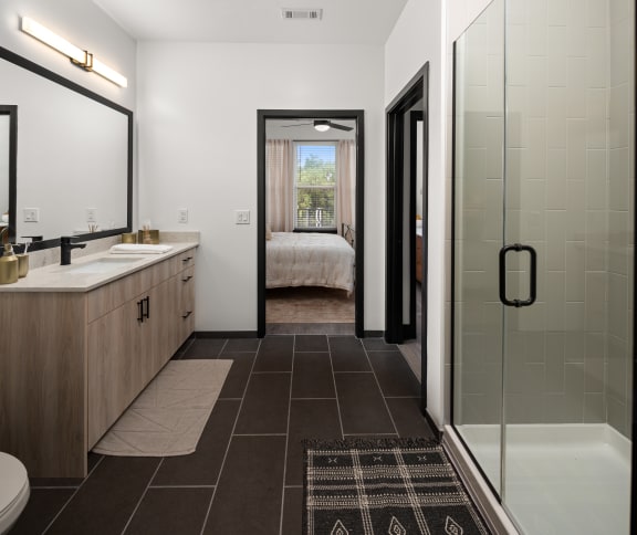 a bathroom with a glass shower stall and a double sink with a large mirror on the wall at Abberly Riverwalk Apartment Homes, Tennessee, 37228