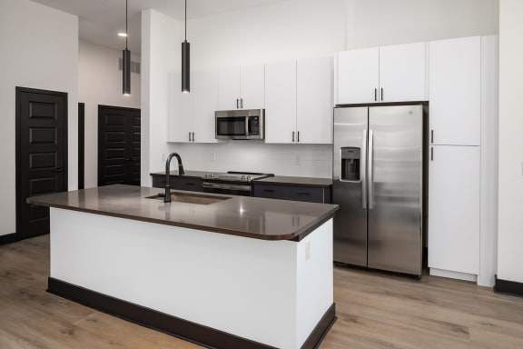 a kitchen with white cabinets and a large island  at Abberly Riverwalk Apartment Homes, Nashville, 37228