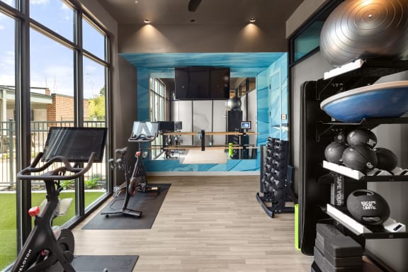a home gym with a blue accent wall and wood flooring  at Abberly Riverwalk Apartment Homes, Nashville, Tennessee