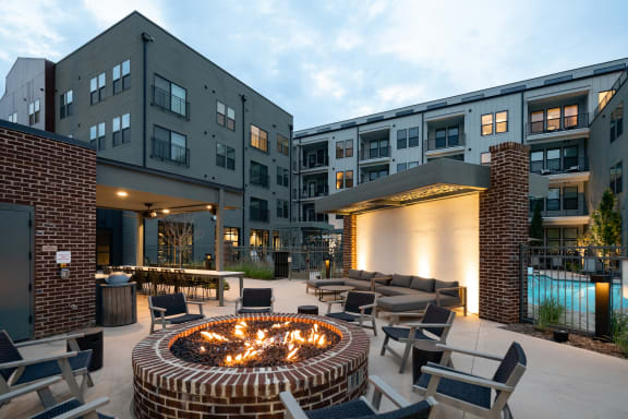 an outdoor patio with a fire pit and lounge chairs at Abberly Riverwalk Apartment Homes, Nashville