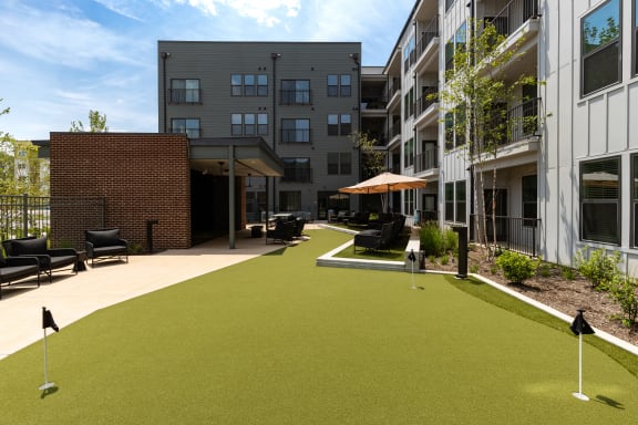 a courtyard with synthetic grass and umbrellas at Abberly Riverwalk Apartment Homes, Nashville, Tennessee