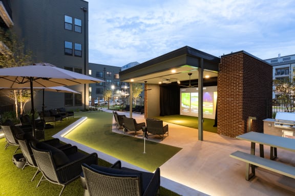 an outdoor lounge area with tables and chairs and a projector screen at Abberly Riverwalk Apartment Homes, Nashville, 37228