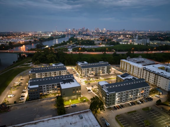 a cityscape at night with a river and a city skyline in the background at Abberly Riverwalk Apartment Homes, Tennessee, 37228
