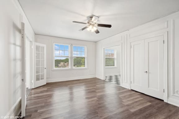 a living room with white walls and a ceiling fan at CWE Apartments, St. Louis, Missouri