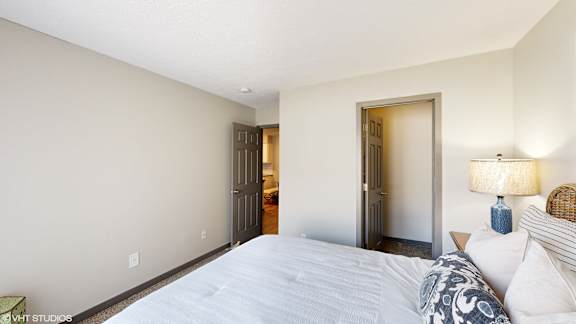 a bedroom with a large bed and a door to a bathroom