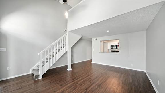 A white staircase with a wooden floor and a small window.