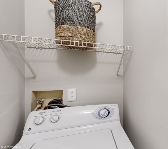 a white washer and dryer in a laundry room with a basket on top at Island Club Apartments, Columbus