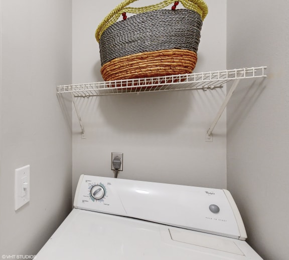 a washer and dryer in a laundry room with a basket on the wall at Island Club Apartments, Columbus, Ohio