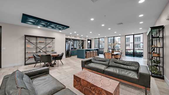 A modern living room with a black leather couch and a wooden coffee table.