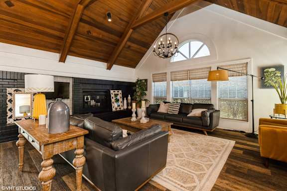 A living room with a black couch and a wooden table. at Island Club Apartments, Ohio