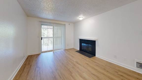 A room with a fireplace and a sliding glass door.
