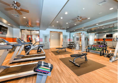 the gym has plenty of exercise equipment and mirrors on the wall