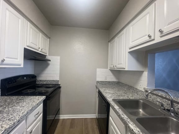 a kitchen with granite counter tops and white cabinets at Whispering Oaks, Conroe Texas ?
