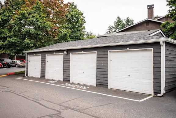 A grey building with three white garage doors.