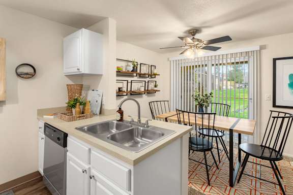 Kitchen peninsula with double sink and open dining space at Bower Village Apartments, Kent