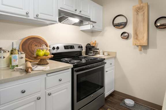 White kitchen featuring stainless steel range and decorative accents at Bower Village Apartments, Washington, 98030