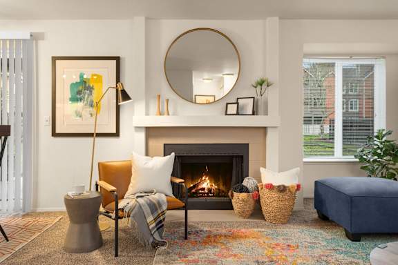 Cozy living room with fireplace and colorful area rug at Bower Village Apartments, Washington, 98030