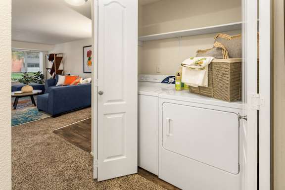 Inunit washer and dryer closet with organized storage at Bower Village Apartments, Kent