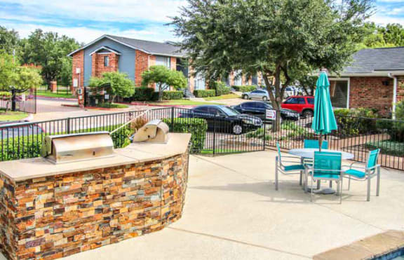 a patio with a table and chairs and a fountain at Water Ridge Apartments, Irving, 75061