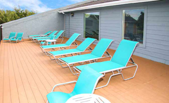 a row of blue lounge chairs on a deck at Water Ridge Apartments, Irving, Texas