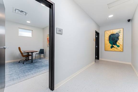 A room with a painting of a green animal on the wall.